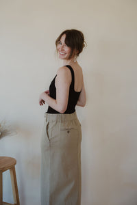 side view of model wearing the in another life skirt. model has the skirt paired with the used to know bodysuit in the color black.