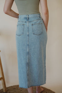 detail view of model wearing the as long as I live denim midi skirt. model has the skirt paired with the used to know bodysuit in the color light moss.
