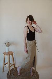 side view of model wearing the in another life skirt. model has the skirt paired with the used to know bodysuit in the color black.