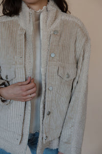 detail view of model wearing the these are the days jacket. model has the jacket paired with the until you top in the color cream.
