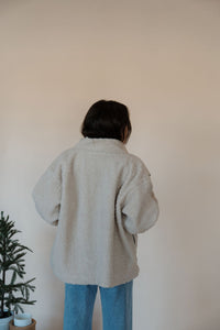back view of model wearing the these are the days jacket. model has the jacket paired with the until you top in the color cream.