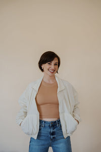 front view of model wearing the cherish the moment jacket in the color white dove. model has the jacket paired with the forever yours top in the color macchiato and the aurora denim.