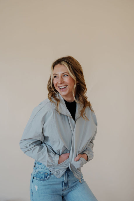 front view of model wearing the cherish the moment jacket in the color misty grey. model has the jacket paired with the never hesitate top in the color black and the charleston denim.