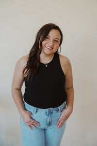 front view of model wearing the change your mind bodysuit in the color black. model has the bodysuit paired with the charleston denim.