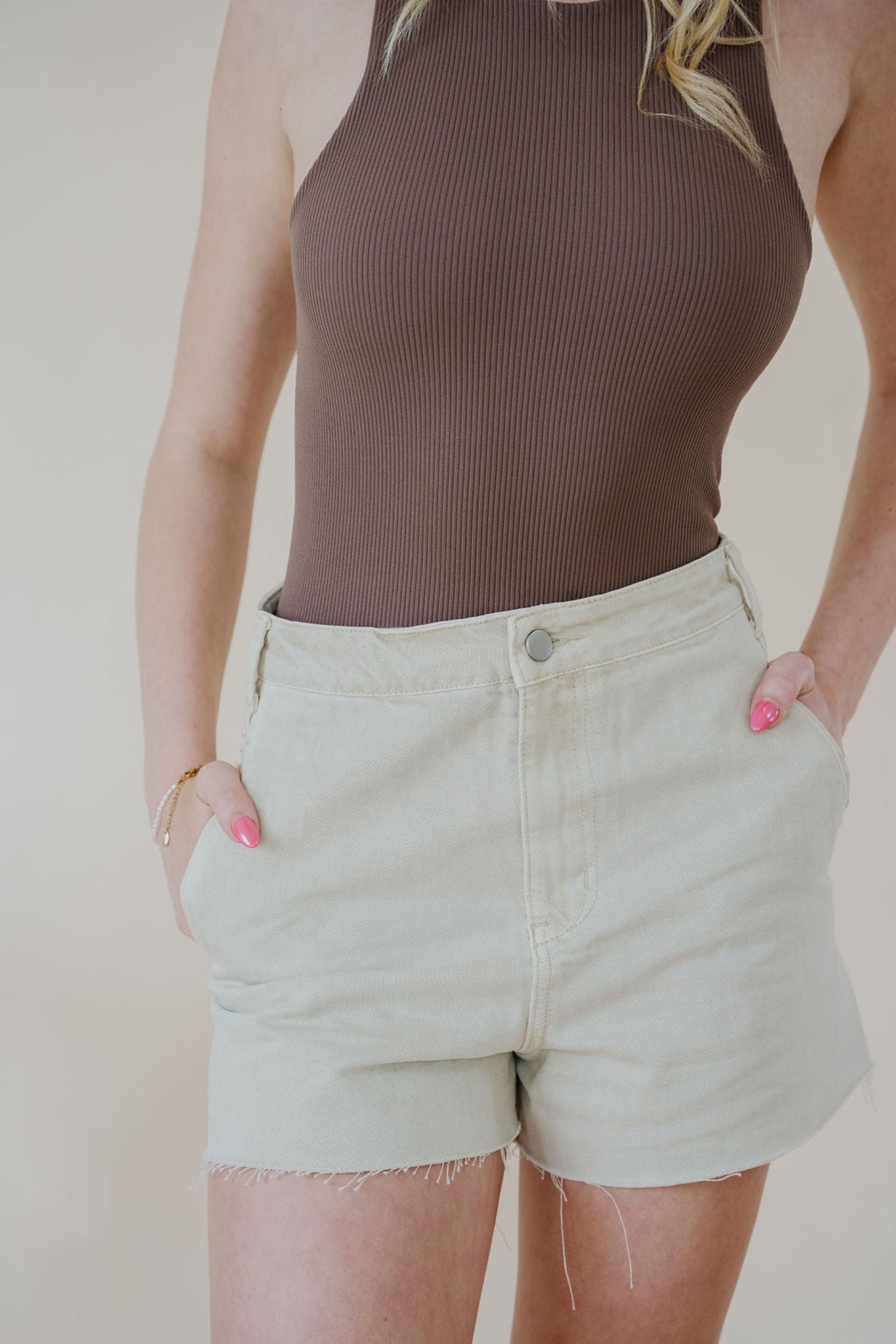 close detail front view of model wearing the parker denim shorts. model has the shorts paired with the change your mind bodysuit in the color walnut and the dainty mallory necklace.
