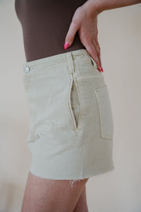 close detail side view of model wearing the parker denim shorts. model has the shorts paired with the change your mind bodysuit in the color walnut and the dainty mallory necklace.