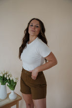 Load image into Gallery viewer, side view of model wearing the hayden denim shorts. model has the shorts paired with the take a chance bodysuit in the color off white and the anna necklace.