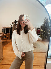 Load image into Gallery viewer, Model taking a mirror selfie wearing the never know sweater in cream and the addison denim.