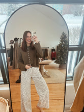 Load image into Gallery viewer, Model taking a mirror selfie wearing the never know sweater in brown and the bittersweet corduroy pants.