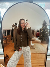 Load image into Gallery viewer, Model taking a mirror selfie wearing the never know sweater in brown and the bittersweet corduroy pants.