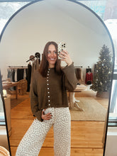 Load image into Gallery viewer, Model taking a mirror selfie wearing the never know sweater in brown and the bittersweet corduroy pants.