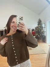 Load image into Gallery viewer, Model taking a mirror selfie wearing the never know sweater in brown and the bittersweet corduroy pants.