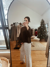 Load image into Gallery viewer, Model taking a mirror selfie wearing the destiny sweater in brown and the bittersweet corduroy pants.