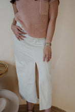 Load image into Gallery viewer, front view of model wearing the all over again denim midi skirt. model has the skirt paired with the nothing to prove top in the color dusty pink.