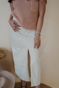 front view of model wearing the all over again denim midi skirt. model has the skirt paired with the nothing to prove top in the color dusty pink.