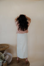 Load image into Gallery viewer, back view of model wearing the all over again denim midi skirt. model has the skirt paired with the nothing to prove top in the color dusty pink.