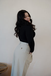 side view of model wearing the Oakland chinos. model has the chinos paired with the after all top in the color black.