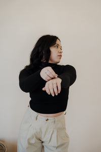 front view of model wearing the after all top in the color black. model has the top paired with the Oakland chinos.