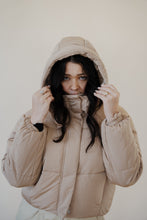 Load image into Gallery viewer, front view of model wearing the where it all began puffer in the color khaki. model has the puffer paired with the all along top in the color black and the oakland chinos.