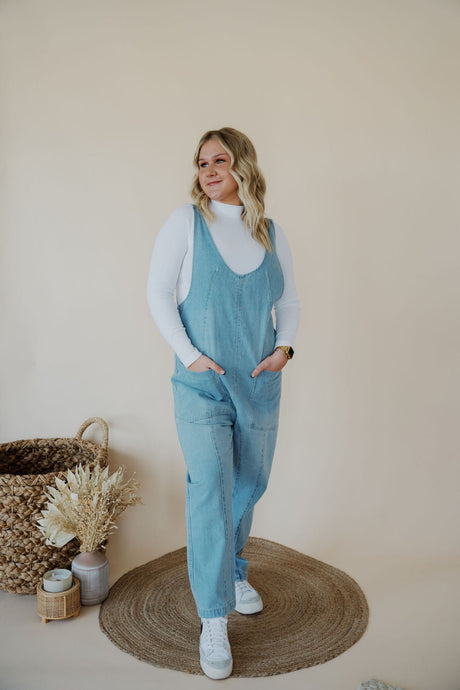 front view of model wearing the clara denim jumpsuit in denim.