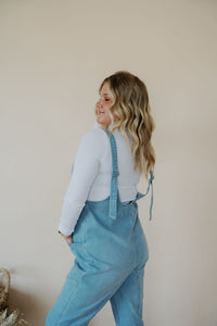 side view of model wearing the clara denim jumpsuit in denim.