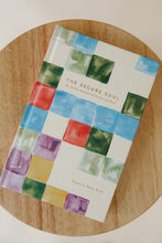 Load image into Gallery viewer, cover photo of &quot;the secure soul: an identity anchored in the love of Christ&quot; devotional book by Tammy L Smith. book is shown sitting on a stool.