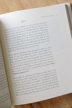 Load image into Gallery viewer, inside page photo of &quot;songs for the suffering&quot; by Julia Allspaw. book is shown sitting on a wooden stool.
