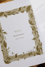 Load image into Gallery viewer, inside page photo of &quot;the everyday banquet: a seasonal devotional for creating rhythms of family worship&quot; by SarahRuth Owens. book is shown sitting on a rattan bench.