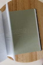 Load image into Gallery viewer, inside page photo of &quot;unfold: discovering the thoughts and intentions of the heart&quot; devotional book by Lisel Lamprecht. book is shown sitting on a stool.