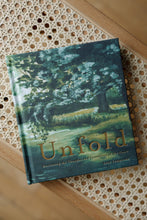 Load image into Gallery viewer, cover photo of &quot;unfold: discovering the thoughts and intentions of the heart&quot; devotional book by Lisel Lamprecht. book is shown sitting on a rattan bench.