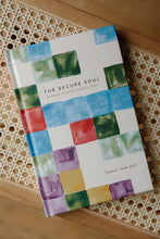 Load image into Gallery viewer, cover photo of &quot;the secure soul: an identity anchored in the love of Christ&quot; devotional book by Tammy L Smith. book is shown sitting on a rattan bench.