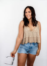 Load image into Gallery viewer, model wearing the moving on top in the color taupe paired with light denim shorts; model is holding a pair of sunglasses in one hand