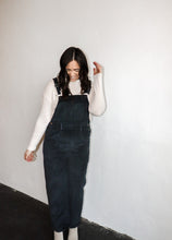Load image into Gallery viewer, model wearing the sweet disposition overalls in the color charcoal. model has the overalls paired with the by your side top in the color cream.