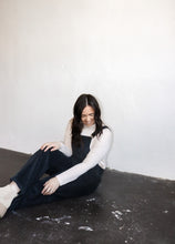 Load image into Gallery viewer, model wearing the sweet disposition overalls in the color charcoal. model has the overalls paired with the by your side top in the color cream.