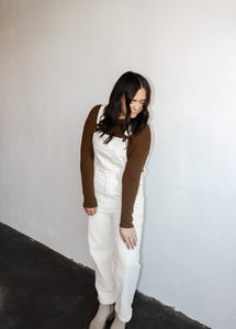model wearing the sweet disposition overalls in the color cream. model has the overalls paired with the by your side top in the color espresso.