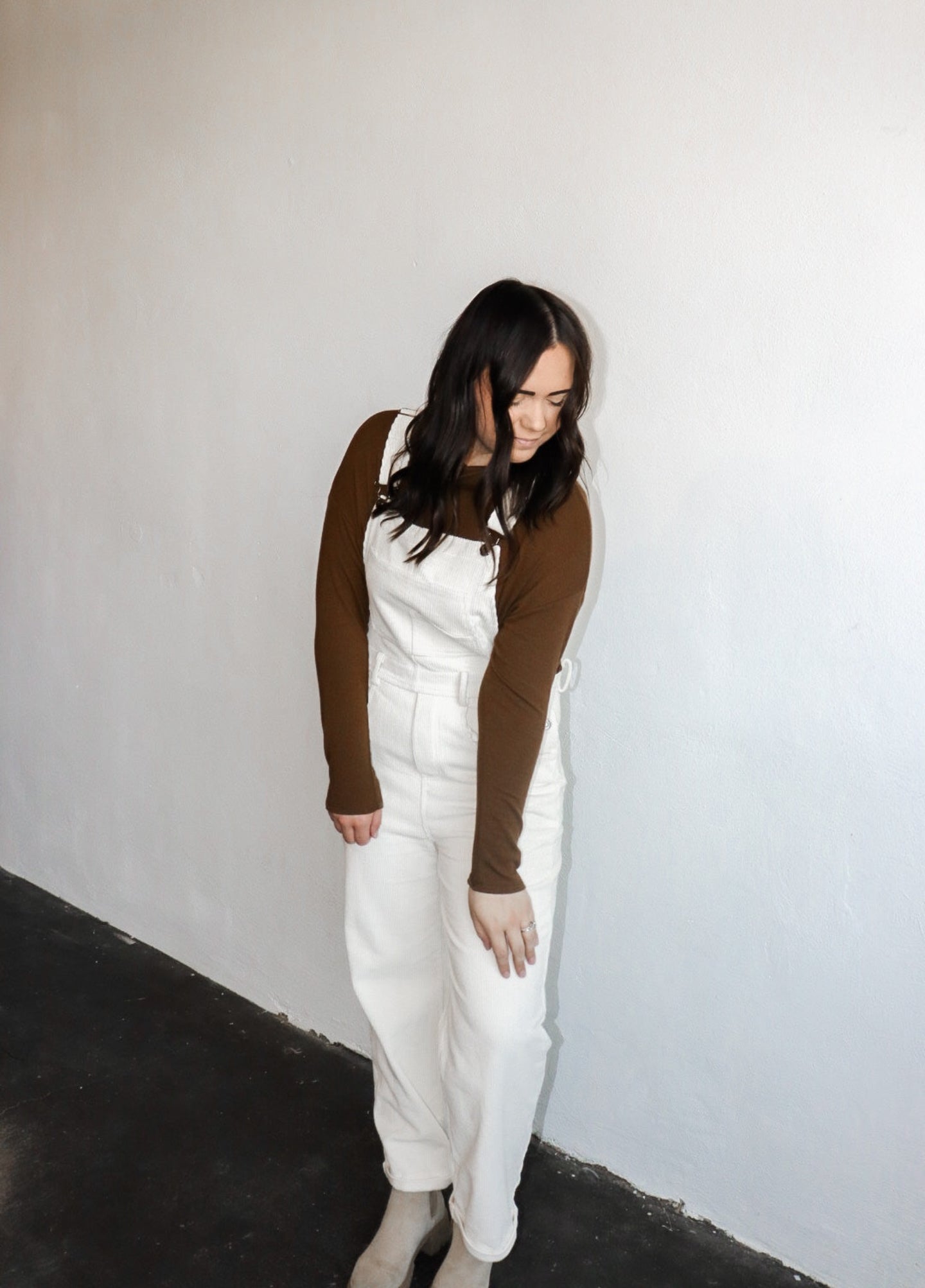 model wearing the sweet disposition overalls in the color cream. model has the overalls paired with the by your side top in the color espresso.