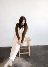 Load image into Gallery viewer, model wearing the sweet disposition overalls in the color cream. model has the overalls paired with the by your side top in the color espresso.