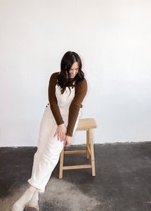 model wearing the sweet disposition overalls in the color cream. model has the overalls paired with the by your side top in the color espresso.