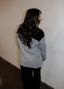 model wearing the never say never jacket in the color black/charcoal. model has the jacket paired with the all along sweater vest and the logan trousers in the color black.