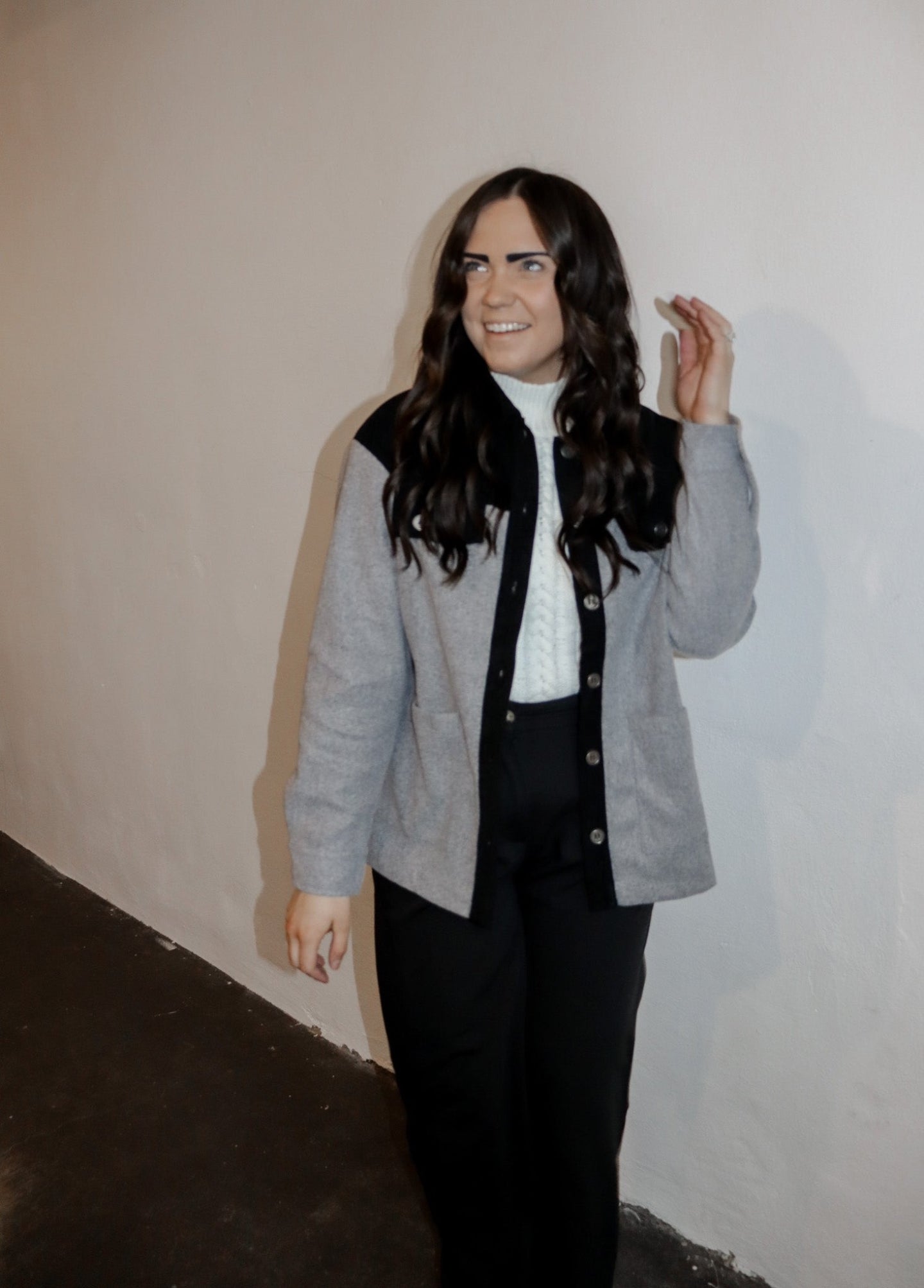 model wearing the never say never jacket in the color black/charcoal. model has the jacket paired with the all along sweater vest and the logan trousers in the color black.