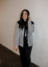 Load image into Gallery viewer, model wearing the never say never jacket in the color black/charcoal. model has the jacket paired with the all along sweater vest and the logan trousers in the color black.